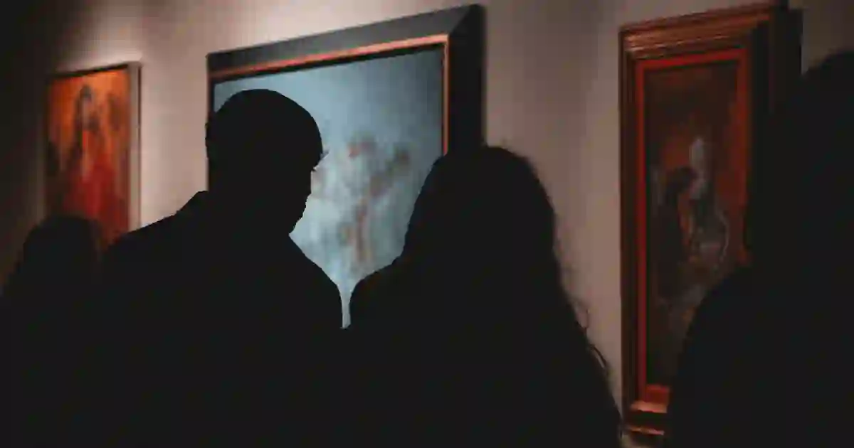 Two visitors in silhouette in front of a painting at a gallery opening in Berlin